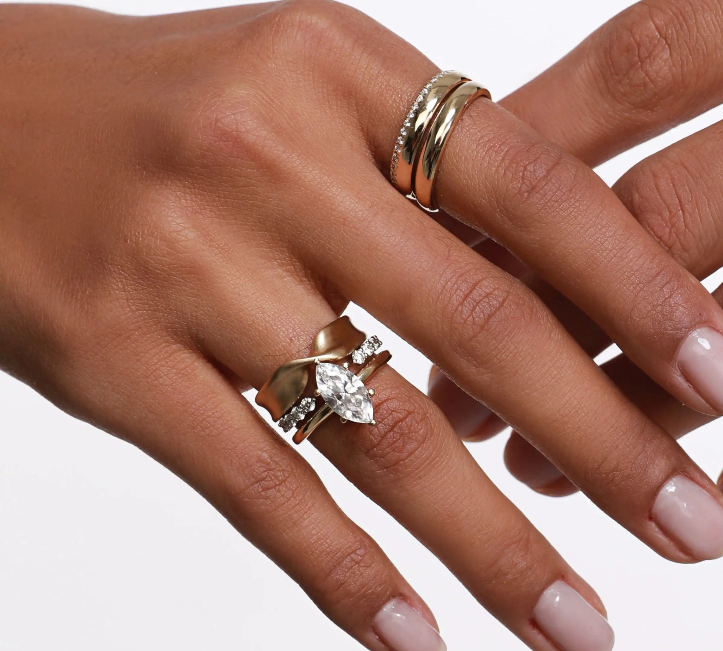 Close up of woman's hand wearing multiple Marrow Fine rings