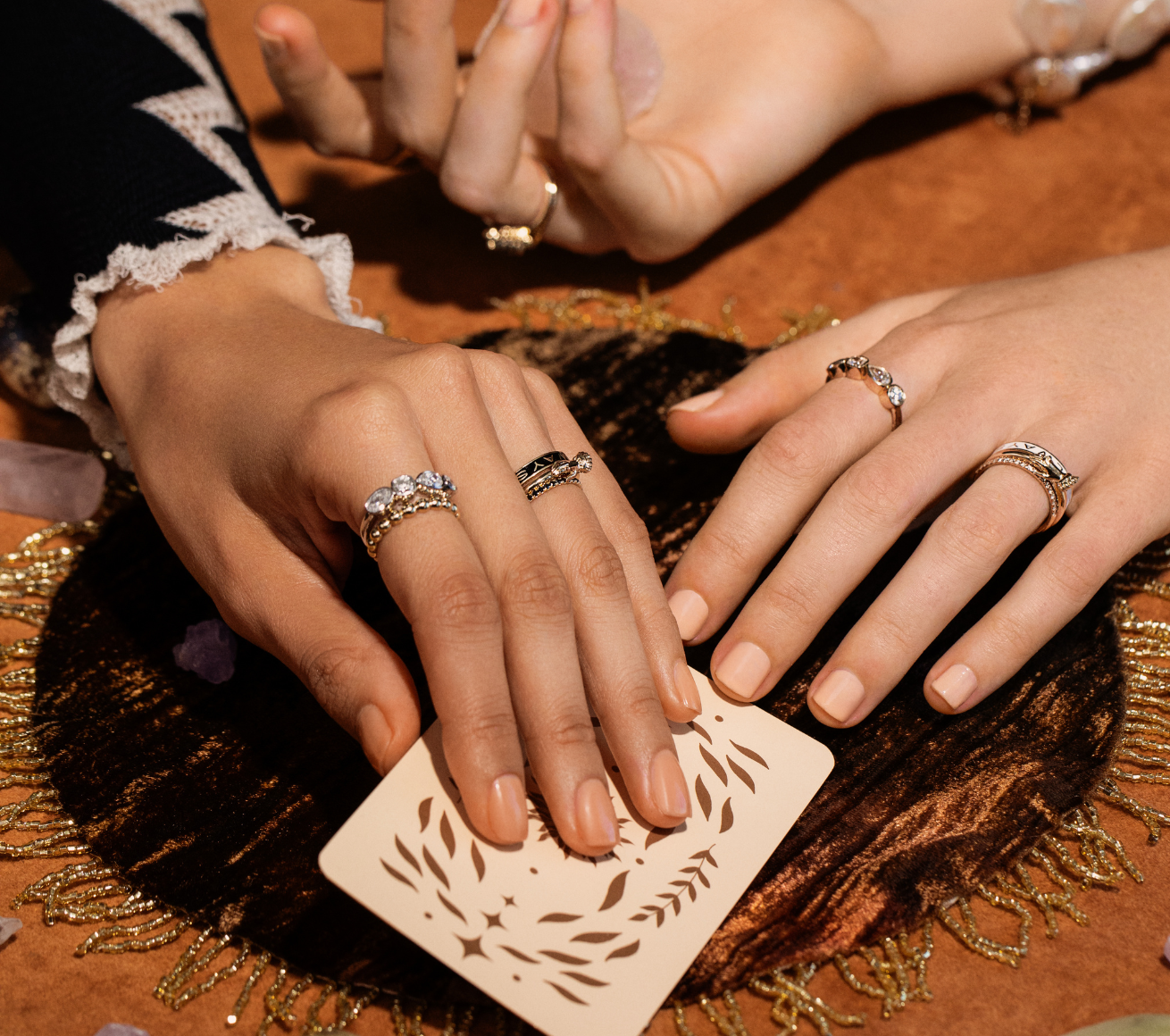 close up of women's hands playing cards with Marrow Fine rings