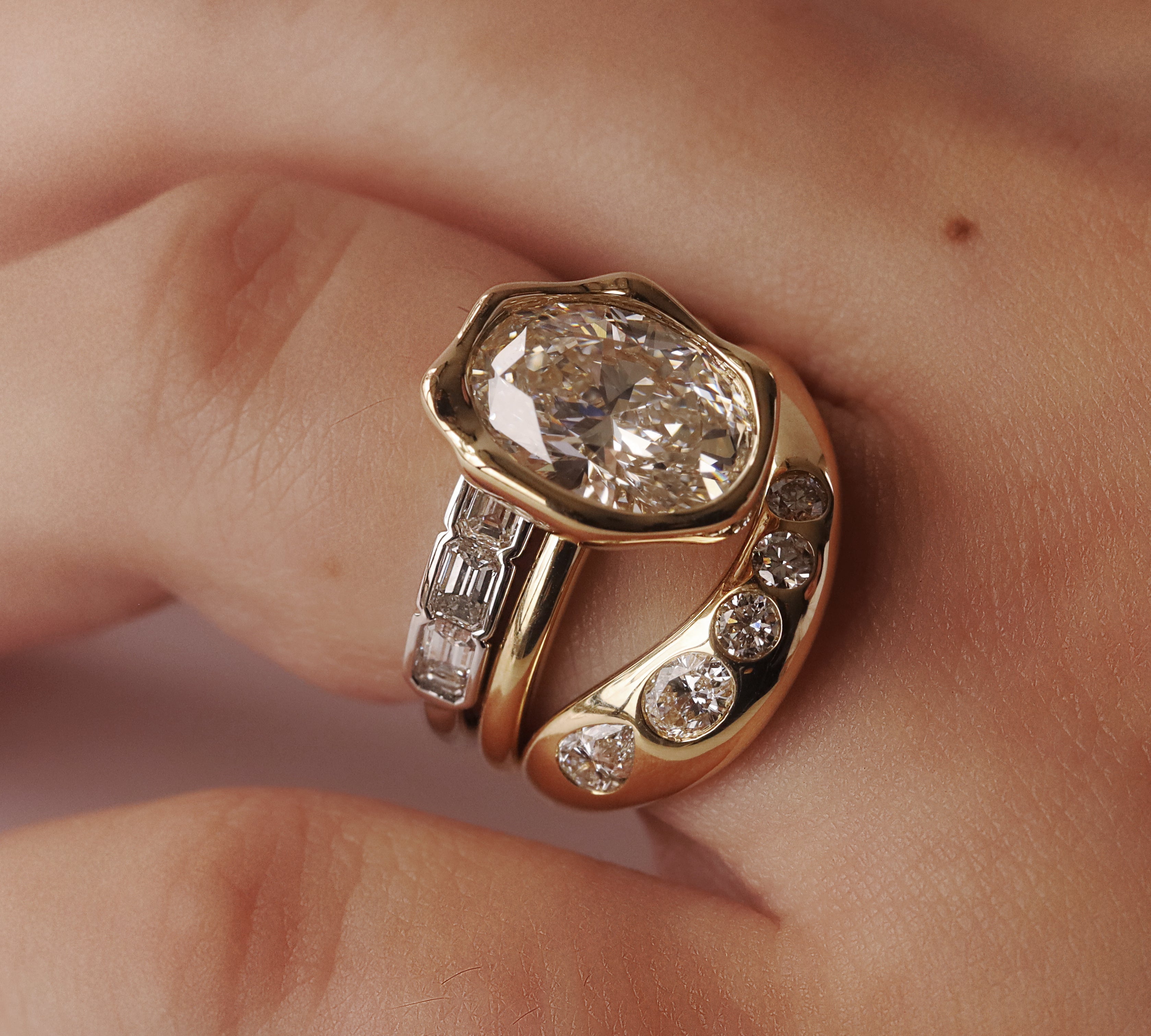 Gold ring with a large diamond and smaller diamonds on a finger