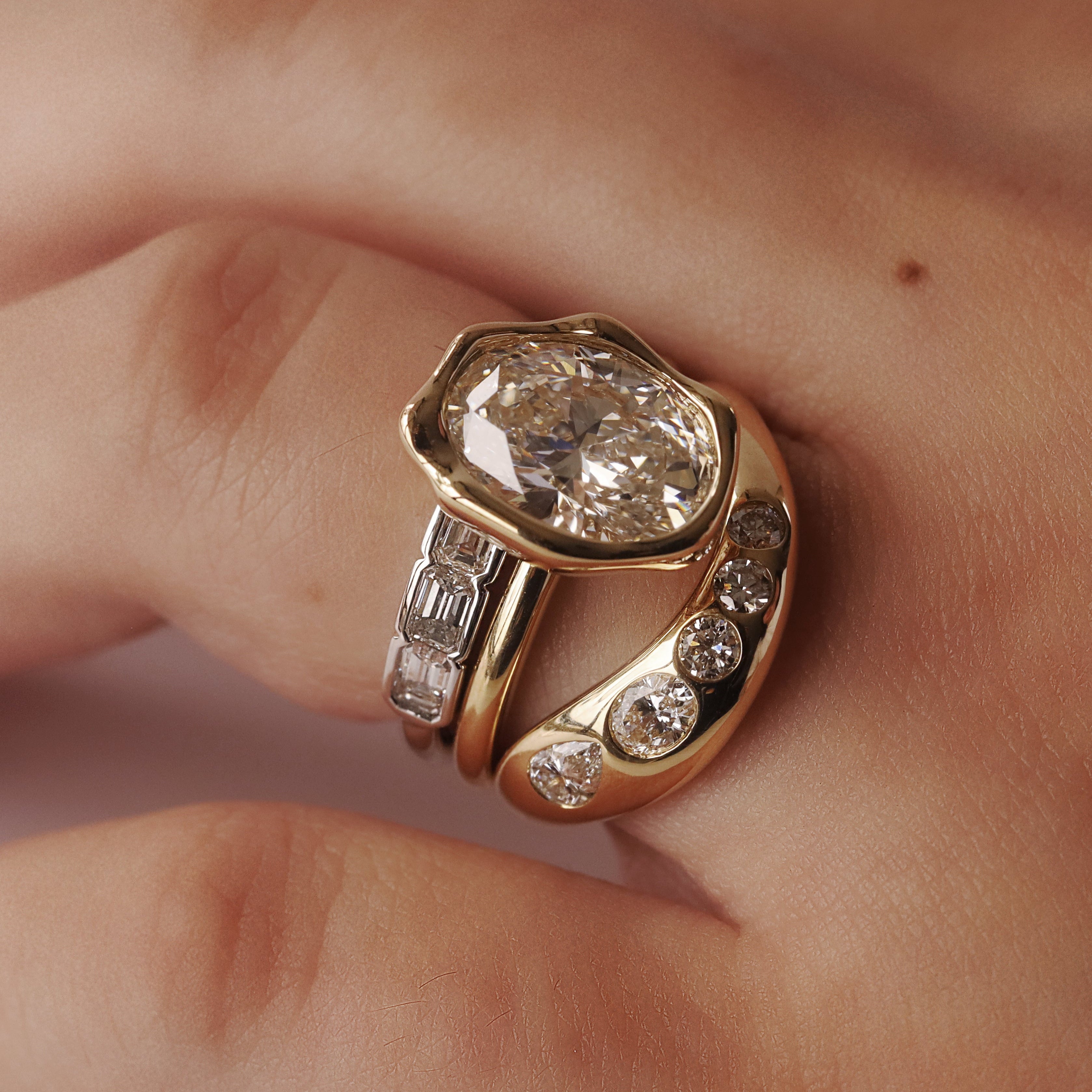 Gold ring with a large diamond and smaller diamonds on a finger