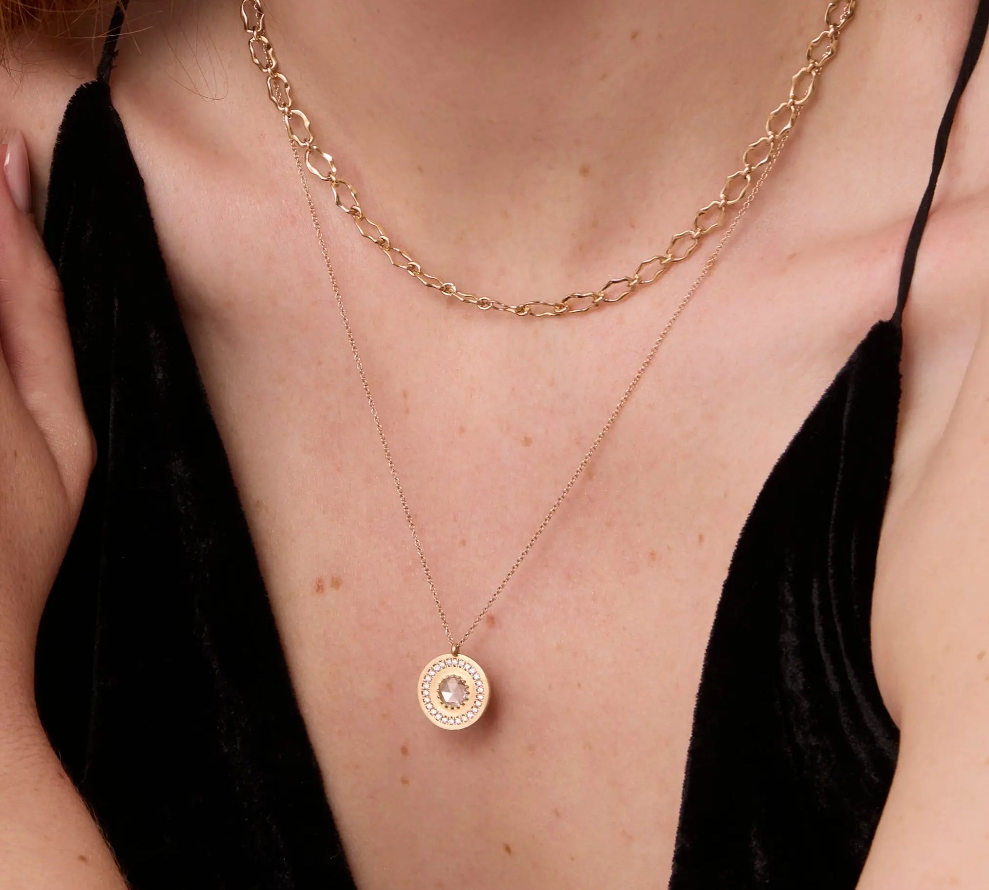 Close up of White Diamond La Femme Amulet on woman's décolletage 