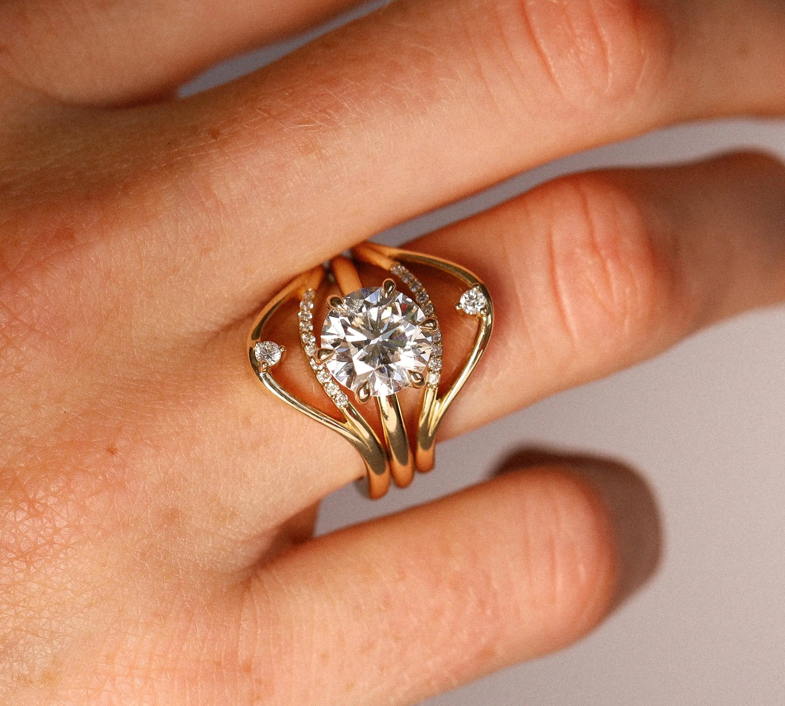 Gold ring with a diamond on a hand against a neutral background