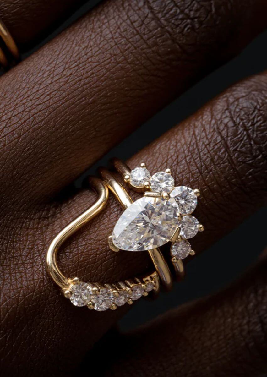 Close up of woman's hand with a Marrow Fine white diamond engagement stack.
