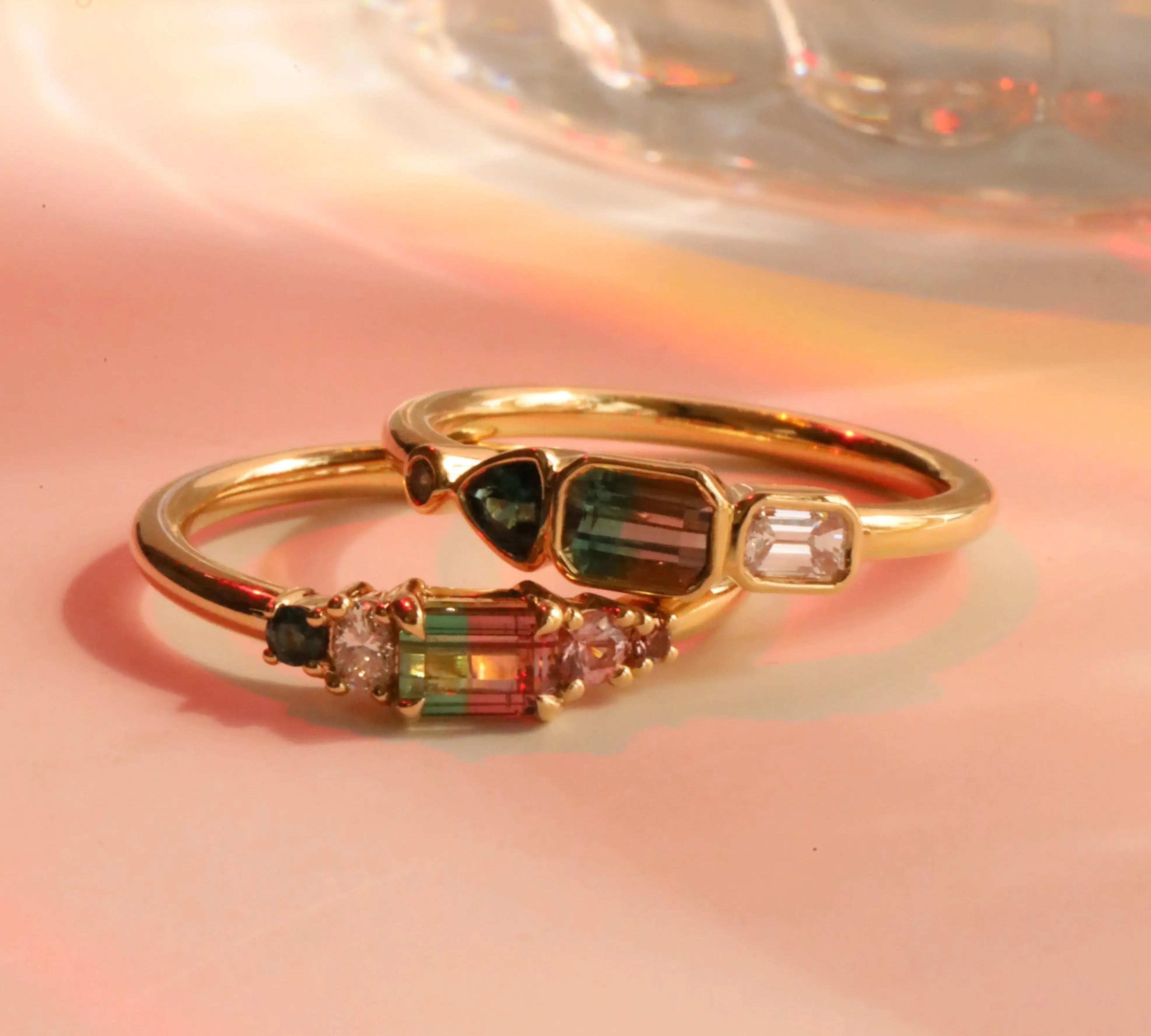 Flat lay of 0.37ct Watermelon Tourmaline, Sapphire, Tourmaline and Diamond Kaleidoscope Ring and 0.44ct Watermelon Tourmaline, Sapphire, Tourmaline and Diamond Kaleidoscope Ring