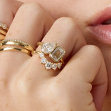 Close-up of a hand wearing multiple gold and diamond rings.