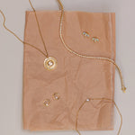 Flat lay on blush tissue paper: White Diamond La Femme pendant, Coco Tennis Bracelet, White Diamond Orbit Studs, Opal Lotus Studs and Dainty Diamond Bezel Bracelet