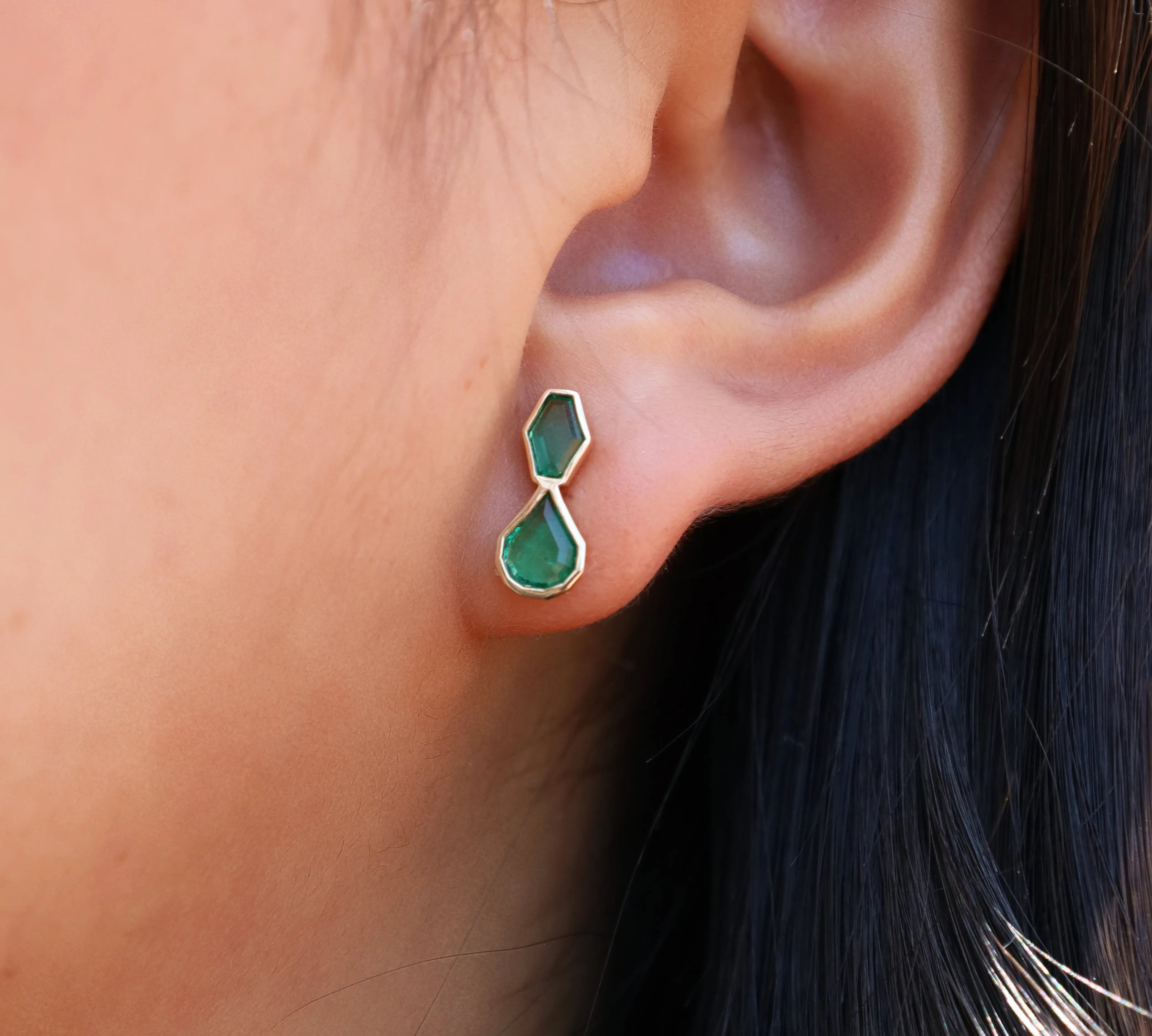 Emerald studs in ear
