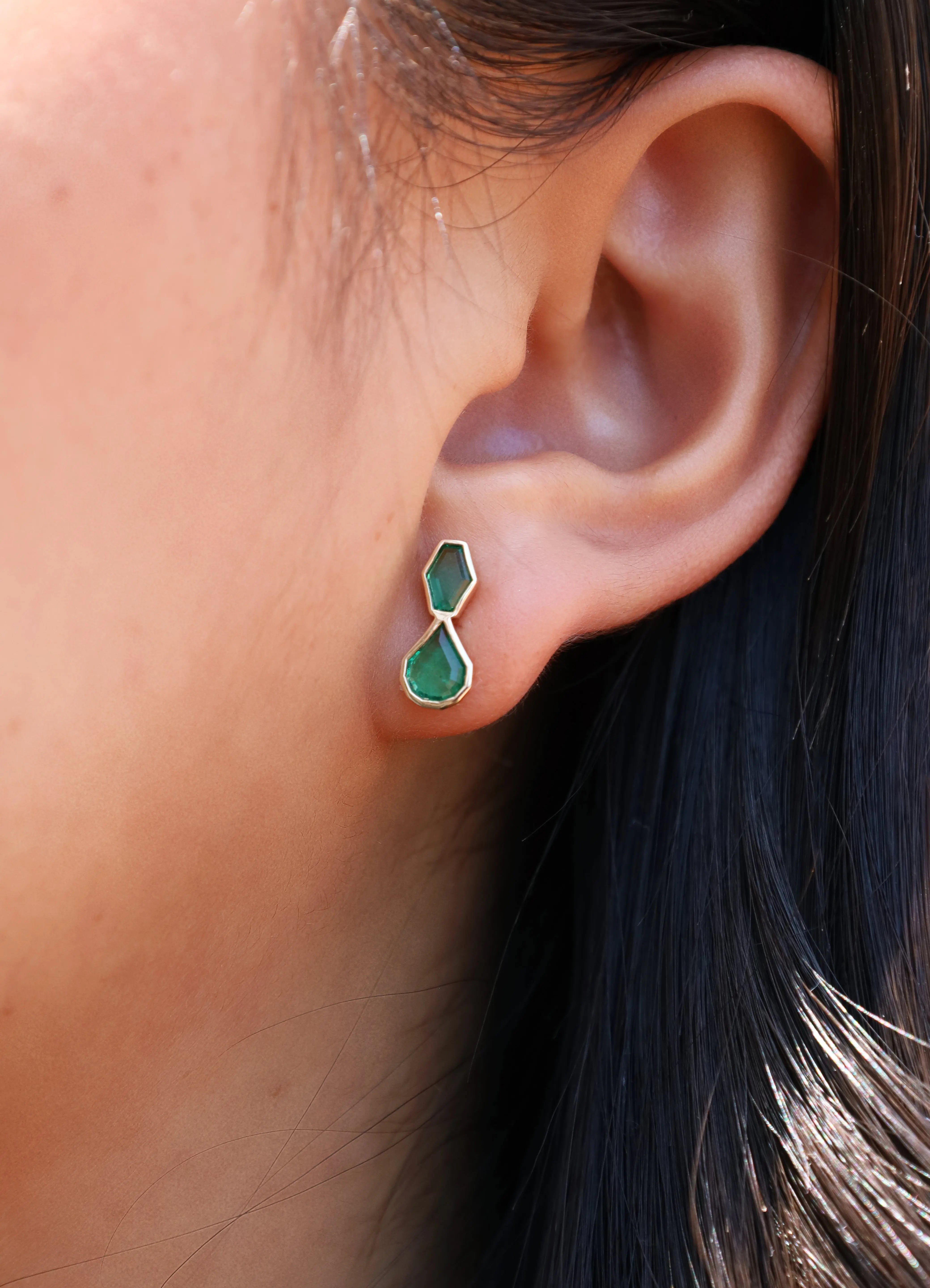 Emerald studs in ear