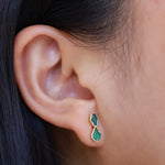 Emerald studs in ear