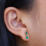 Emerald studs in ear