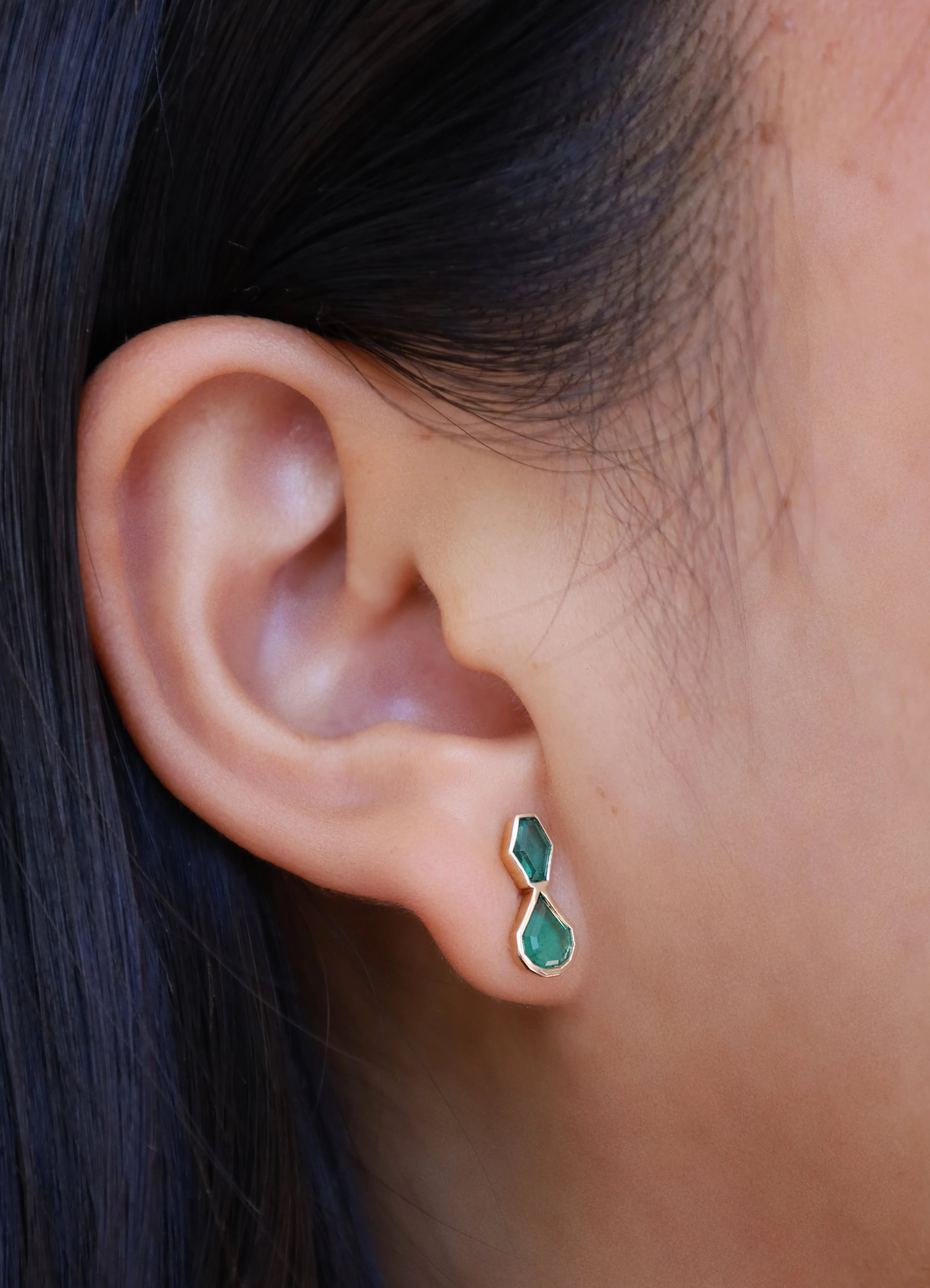 Emerald studs in ear
