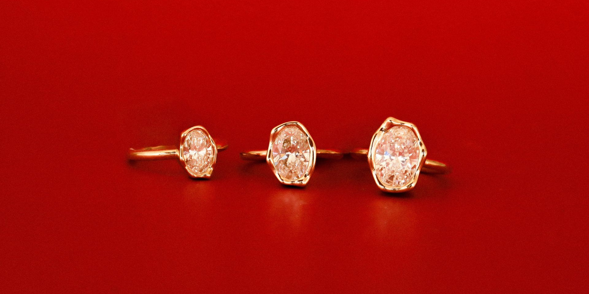 Three diamond stud earrings on a red background