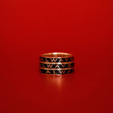 Three black enamel Always Gold Memory Rings stacked on top of each other against a red backdrop