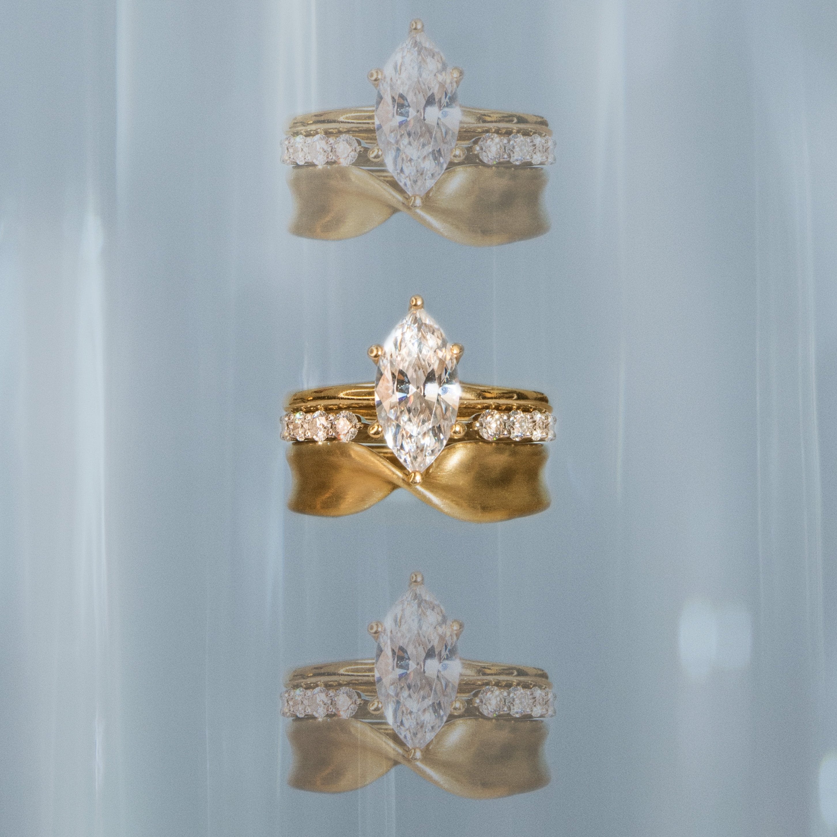 Flat lay of Marrow Fine marquise diamond engagement ring with the White Diamond Cosmic Light Band and the Everyday Twist Band 