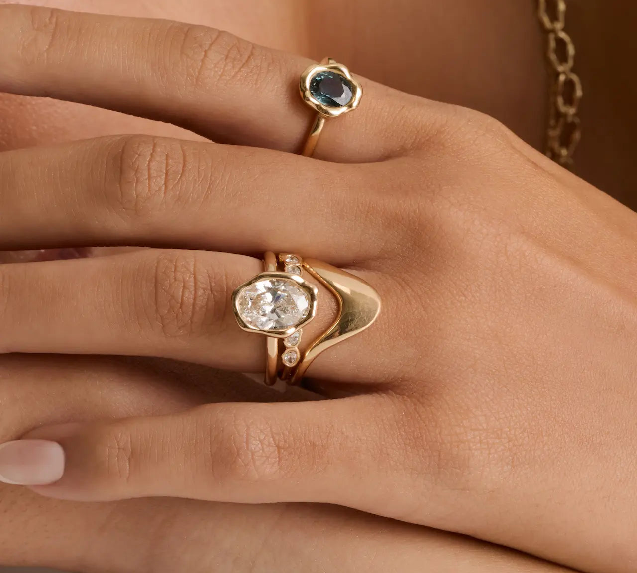 The Abstract Bezel Oval Engagement Ring stacked with the Asymmetrical Sculpted Band and White Diamond Abstract Bezel Band on hand