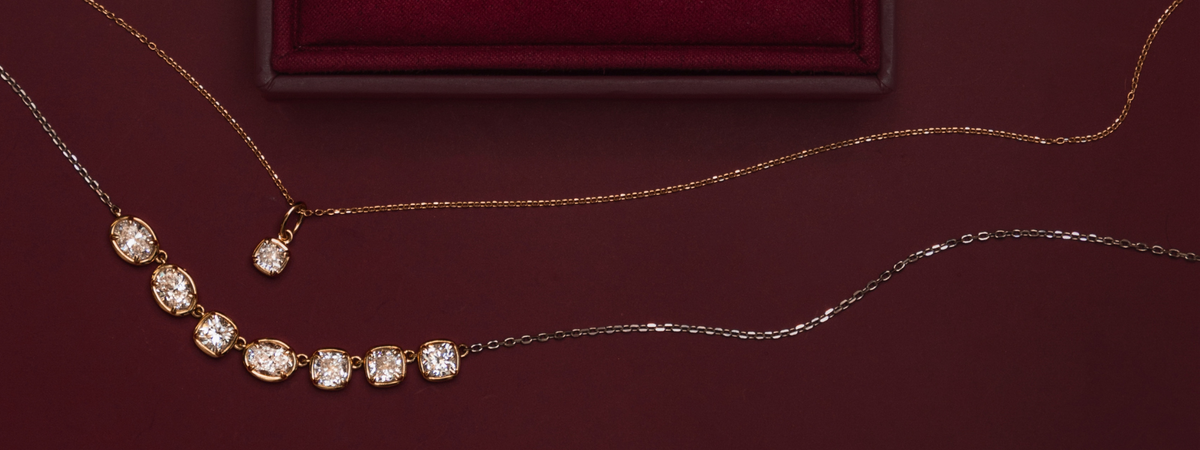 Diamond necklaces draped across a deep burgundy background