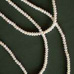 Pearl necklace on a dark green background