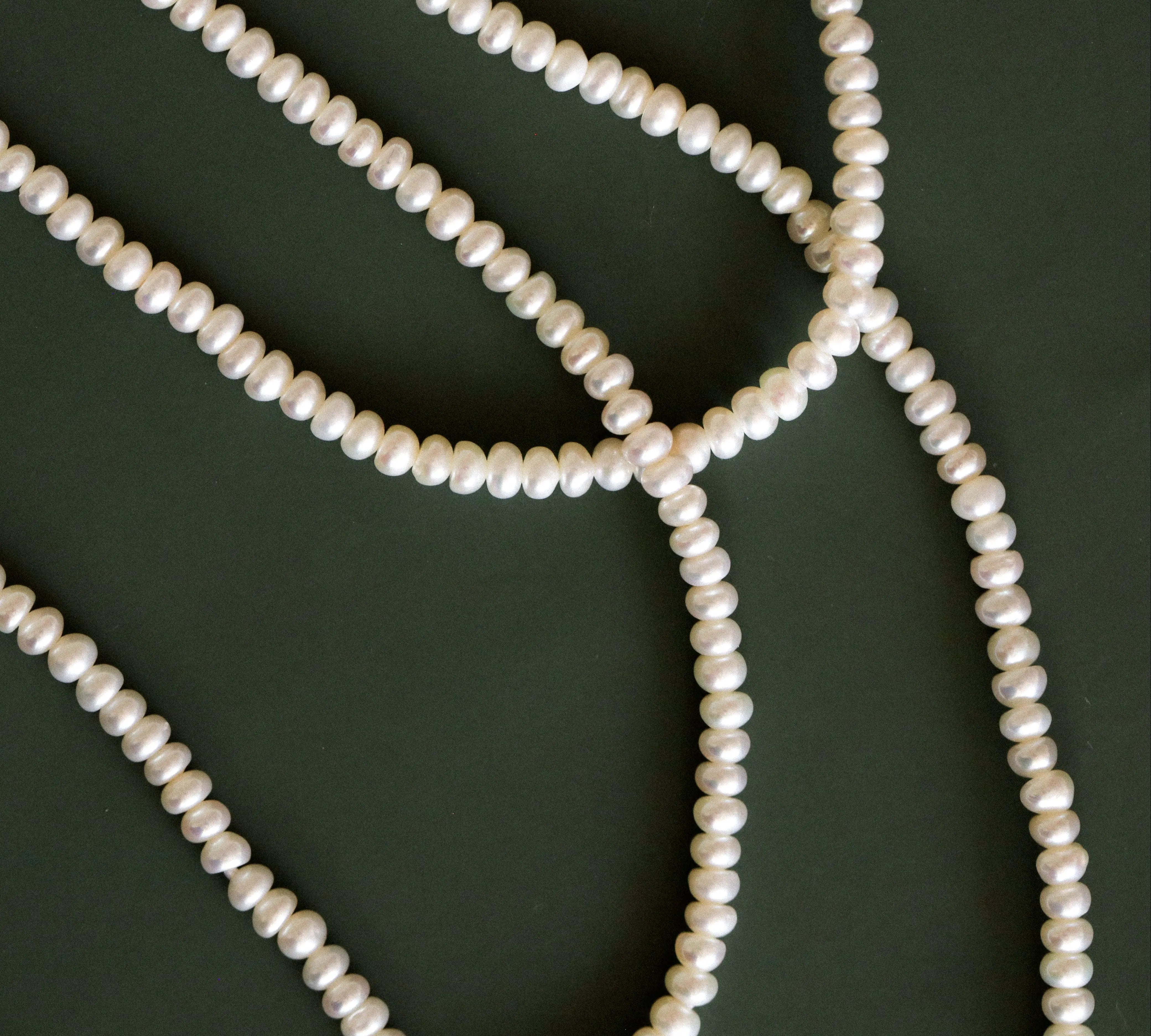 Pearl necklace on a dark green background