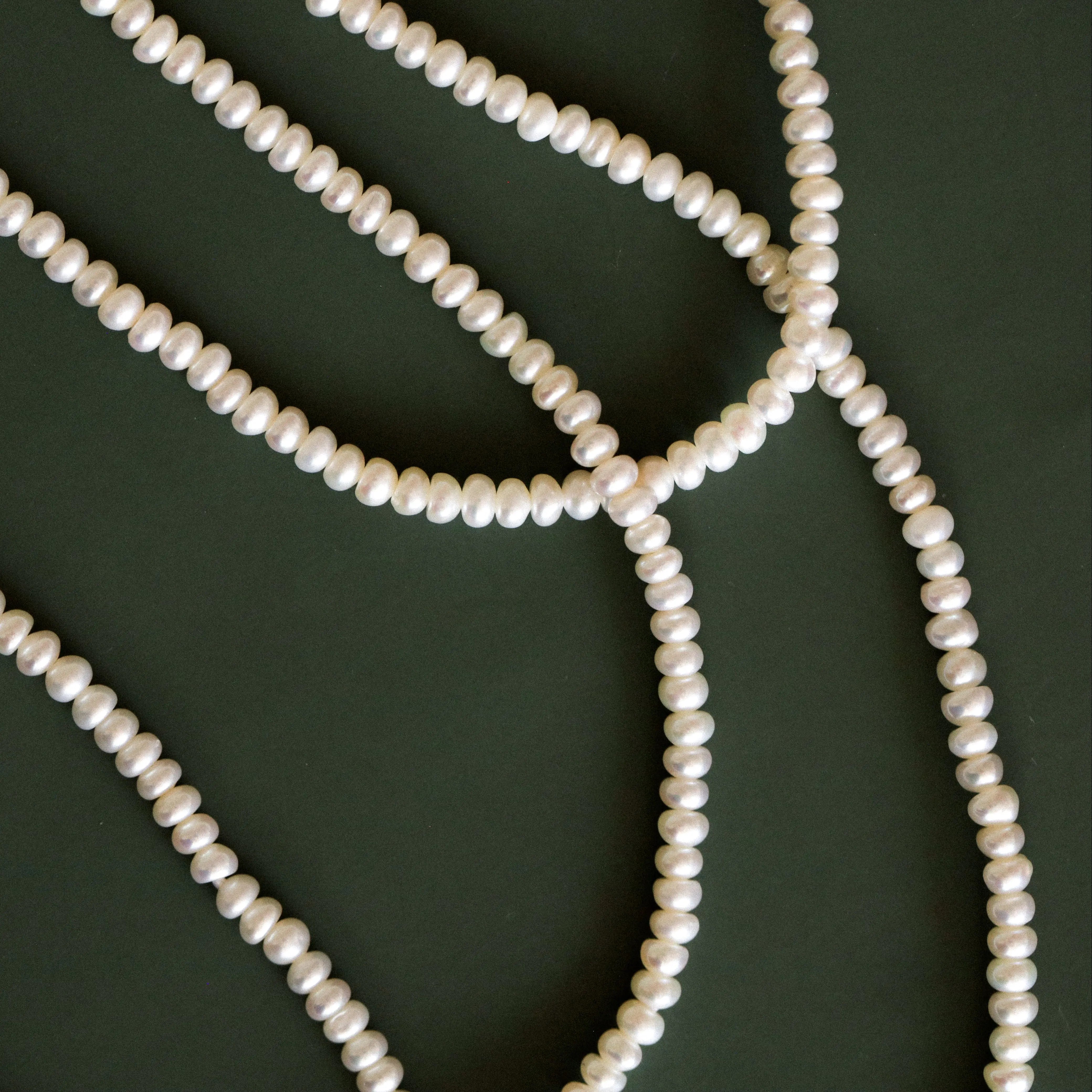 Pearl necklace on a dark green background