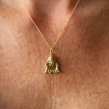 Gold necklace with a small pendant on a person's neck