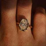 Gold ring with a large diamond on a finger