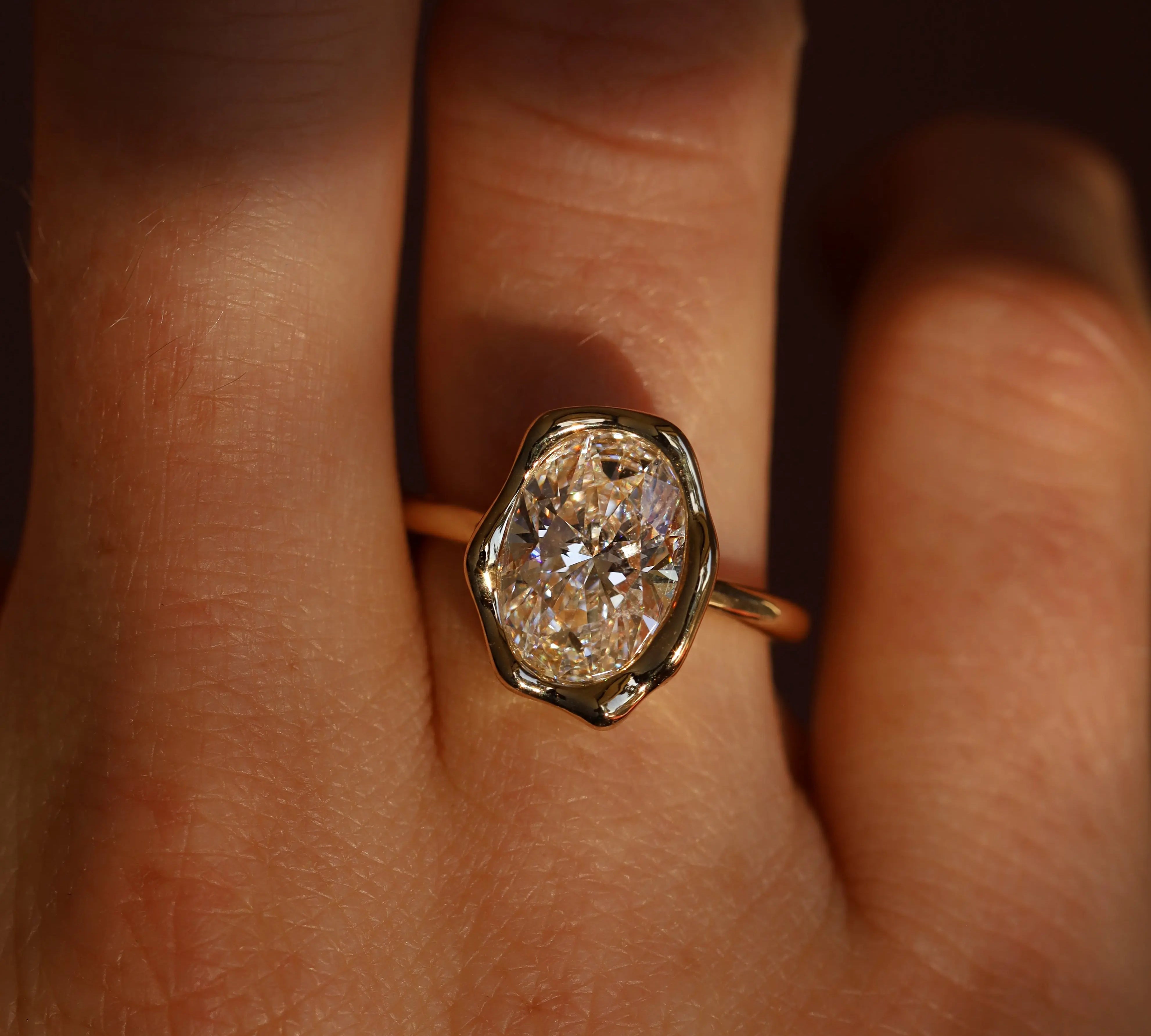 Gold ring with a large diamond on a finger