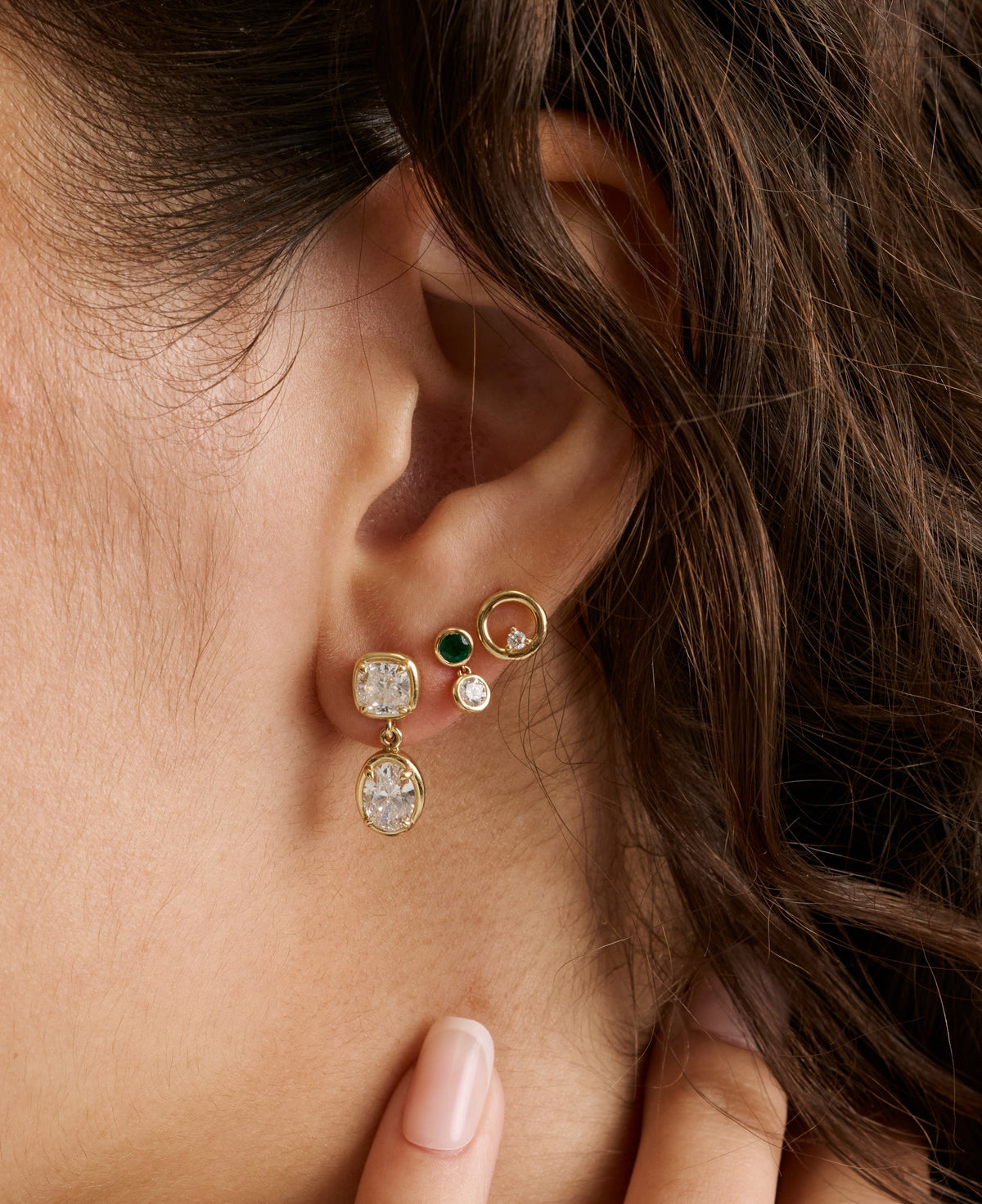Ear stack with a Mini Lisse earring, an emerald and diamond stud and an In Orbit hoop