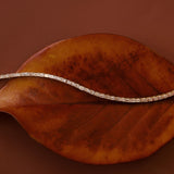 Evert Emerald Lab Created Tennis Bracelet styled over a leaf against a brown-red background