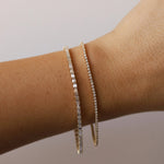 Evert Emerald Lab Grown Tennis Bracelet + Coco Tennis Bracelet on wrist against a neutral light background