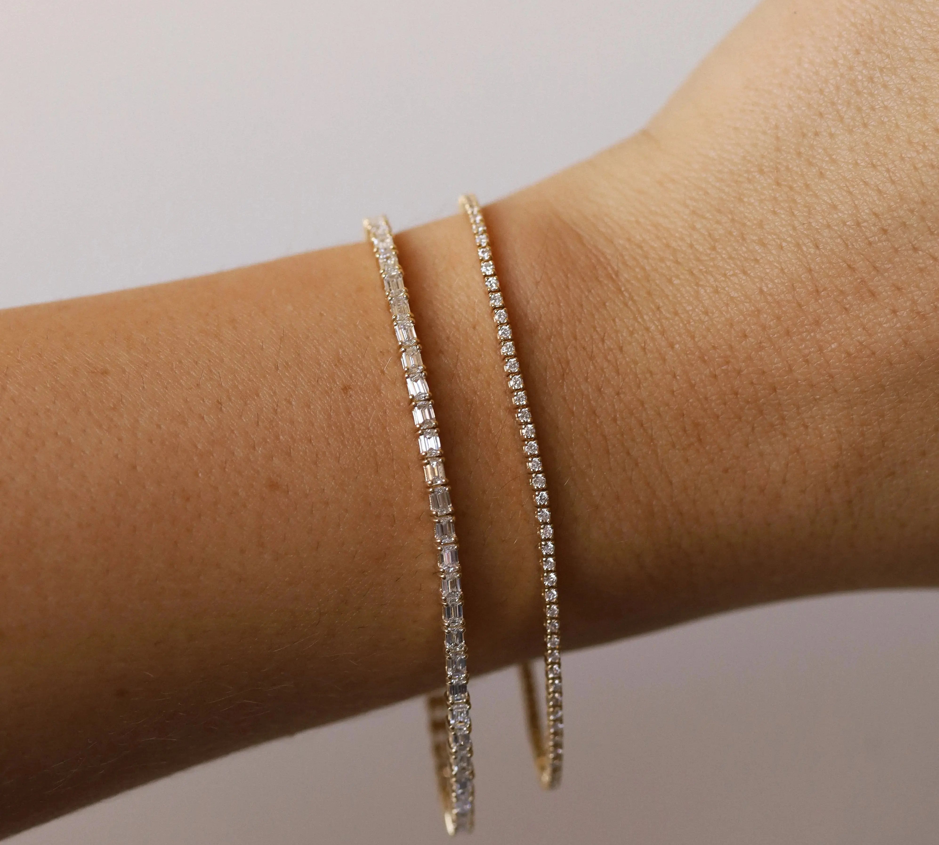 Evert Emerald Lab Grown Tennis Bracelet + Coco Tennis Bracelet on wrist against a neutral light background