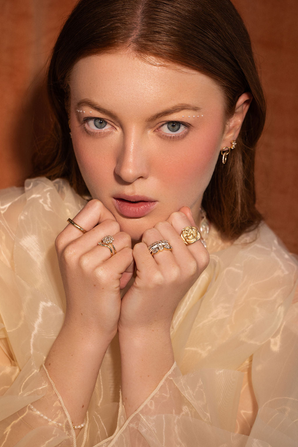 woman looking at the camera with Marrow Fine jewelry on (rings and earrings)