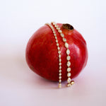 lisse tennis bracelet comparison (regular and mini) both draped over a pomegranate, against a white/pink background