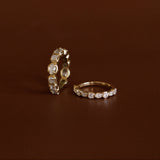 Two gold rings with diamond accents on a brown background
