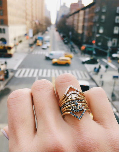 hand with Marrow Fine rings over city landscape