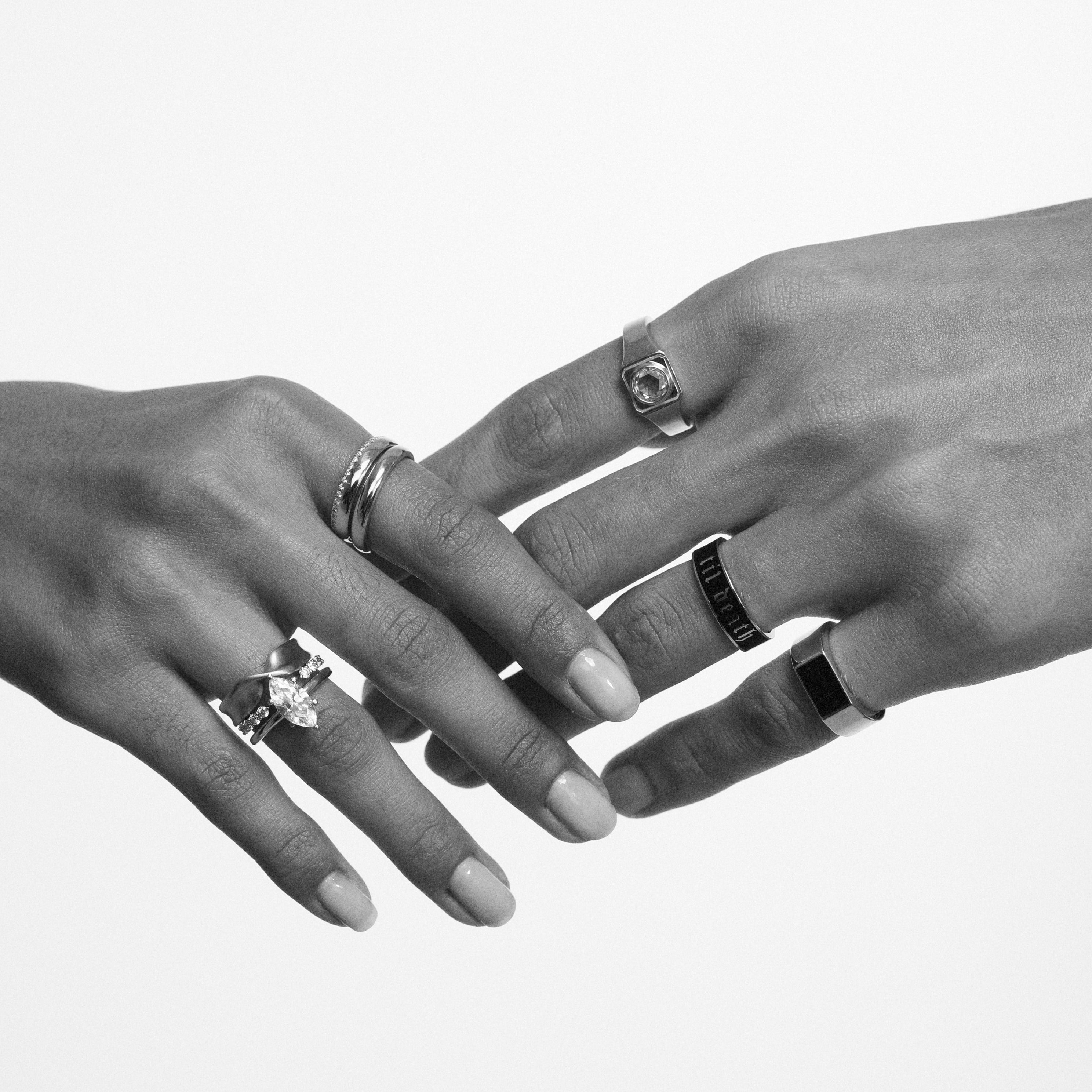 Two hands with rings on a white background