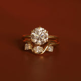 Gold ring with a large diamond and smaller diamonds on a brown background