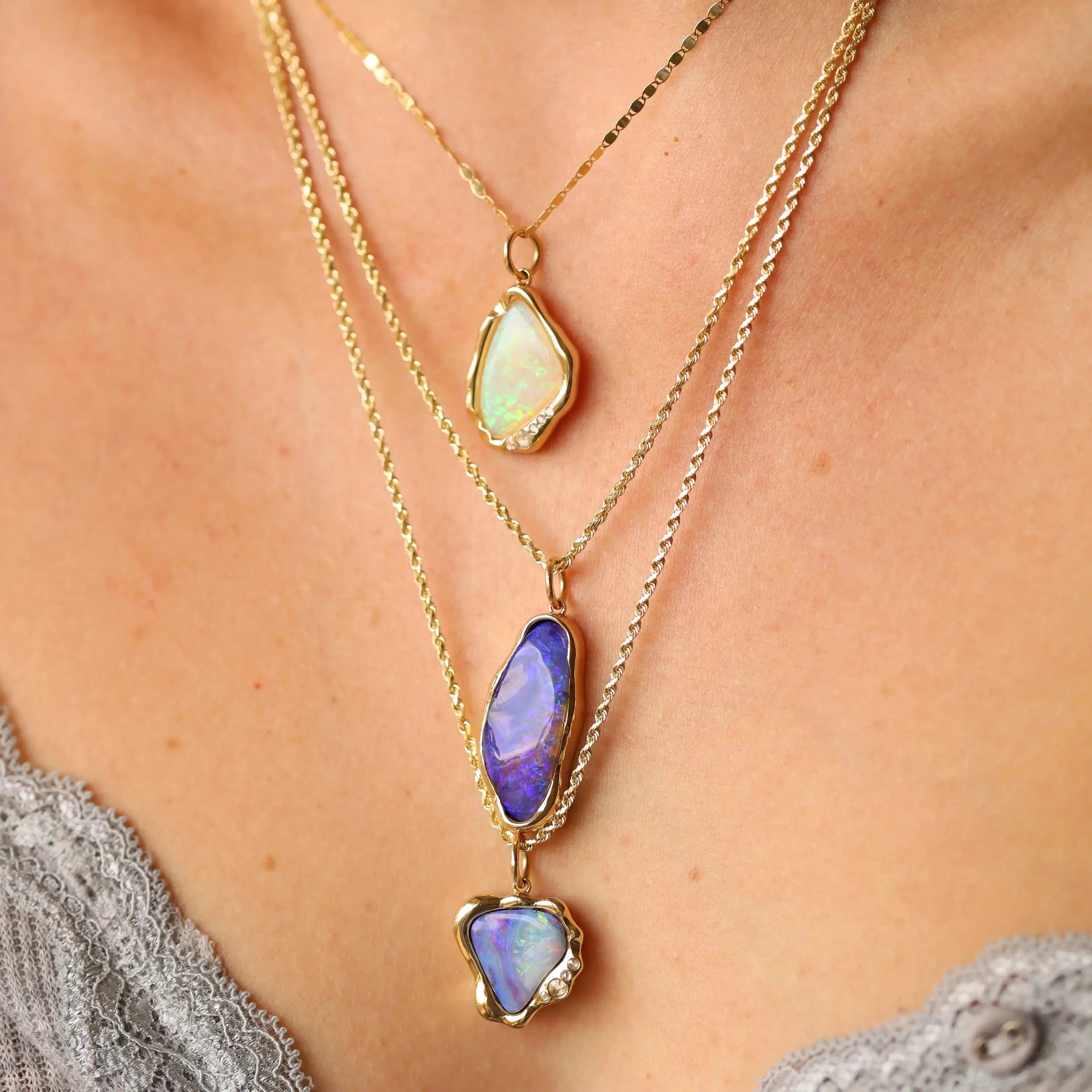 Necklace with opal pendants on a person wearing a gray top.