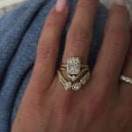 The Emma Engagement Ring on hand, stacked with other diamond bands, hand against denim in background