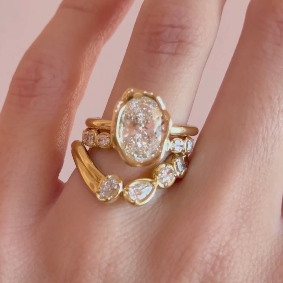 Video of the Simone Arch Band nested under The Abstract Bezel Oval Engagement Ring on hand