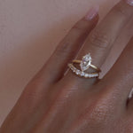 Video of the White Diamond Estelle Wave Band nested with a pear diamond engagement ring on hand