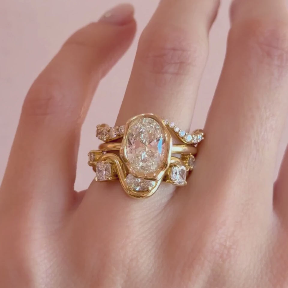 Video of the Arno Serpentine Band and Curved Pavé White Diamond Ring stacked with The Abstract Bezel Oval Engagement Ring on hand