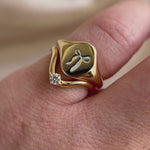 Video of the Blue Keepsake Signet Ring with a bow motif stacked with a curved diamond band on hand