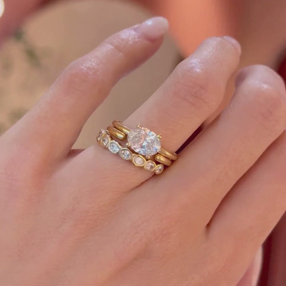 Video of The Hazel East West Oval Engagement Ring stacked with the Everyday Cosmic Light Band and the White Diamond Abstract Bezel Band on hand