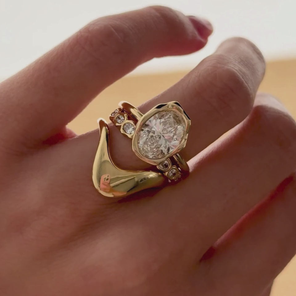 Video of the White Diamond Bombé Band stacked with a pear diamond engagement ring on hand