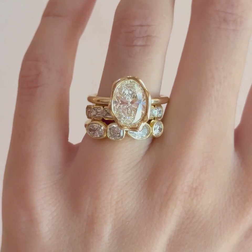 Video of The Abstract Bezel Oval Engagement Ring stacked with the White Diamond Harley Ring and White Diamond Mixed Shape Bezel Band on hand