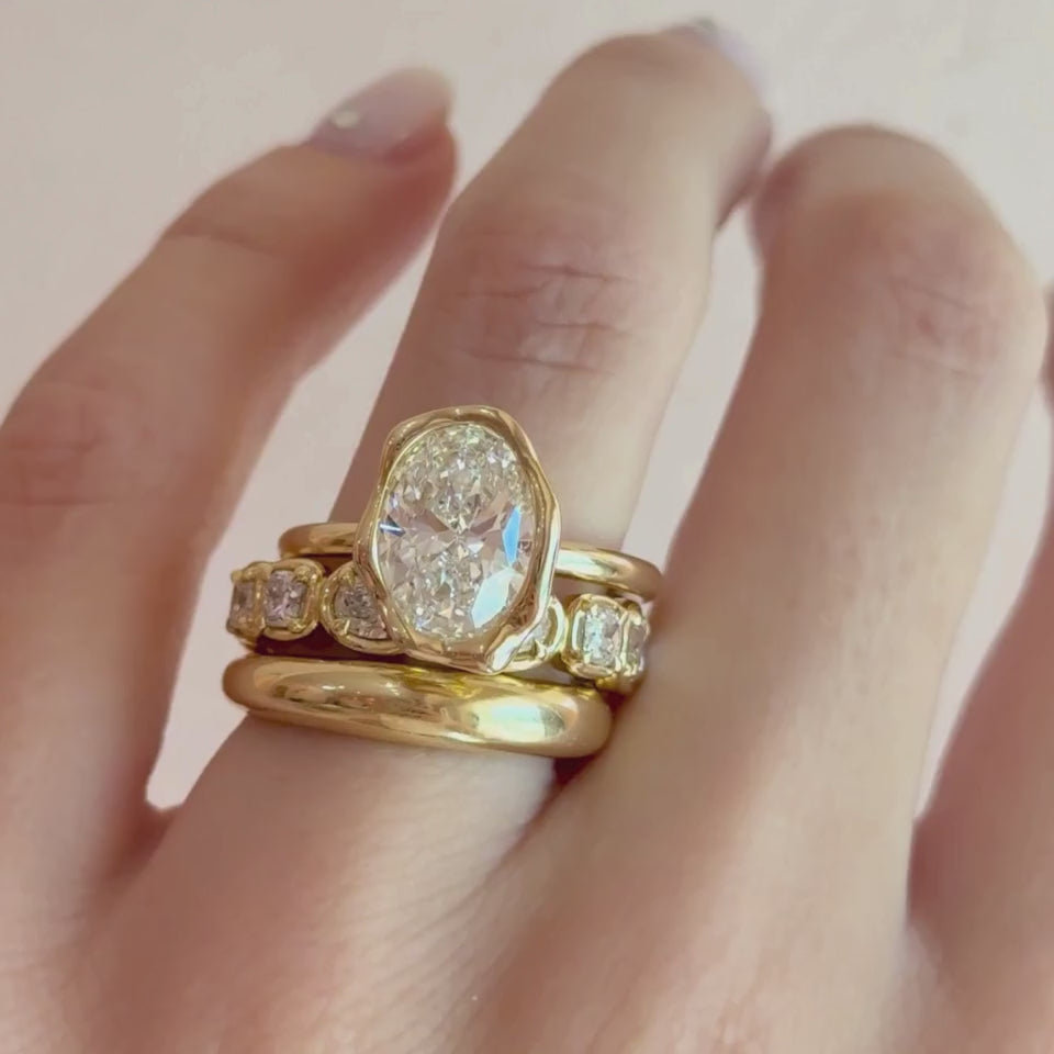 Video of The Abstract Bezel Oval Engagement Ring stacked with the Everyday Dome Ring and Lisse Eternity Band on hand