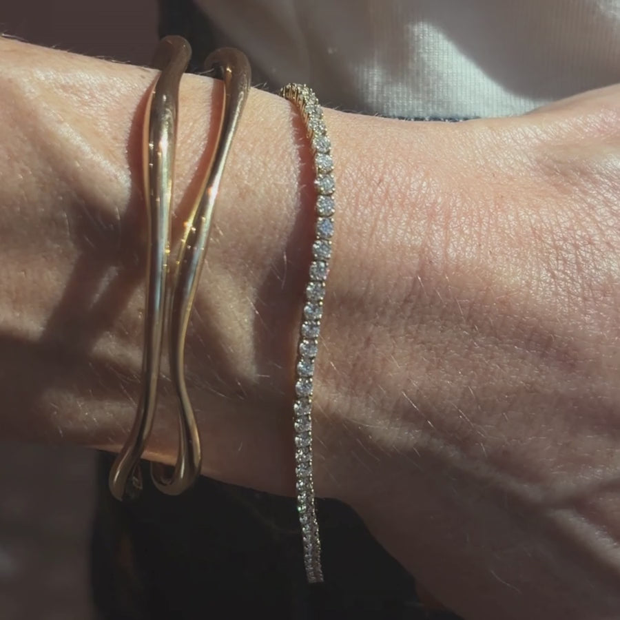 Video fo Maria Tennis Bracelet and Curved Freeform Gold Cuff in yellow gold on woman's wrist