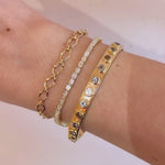 Video of an 8mm sculpted gold link bracelet stacked with the Evert Diamond Tennis Bracelet and a bezel-set gold cuff on the wrist