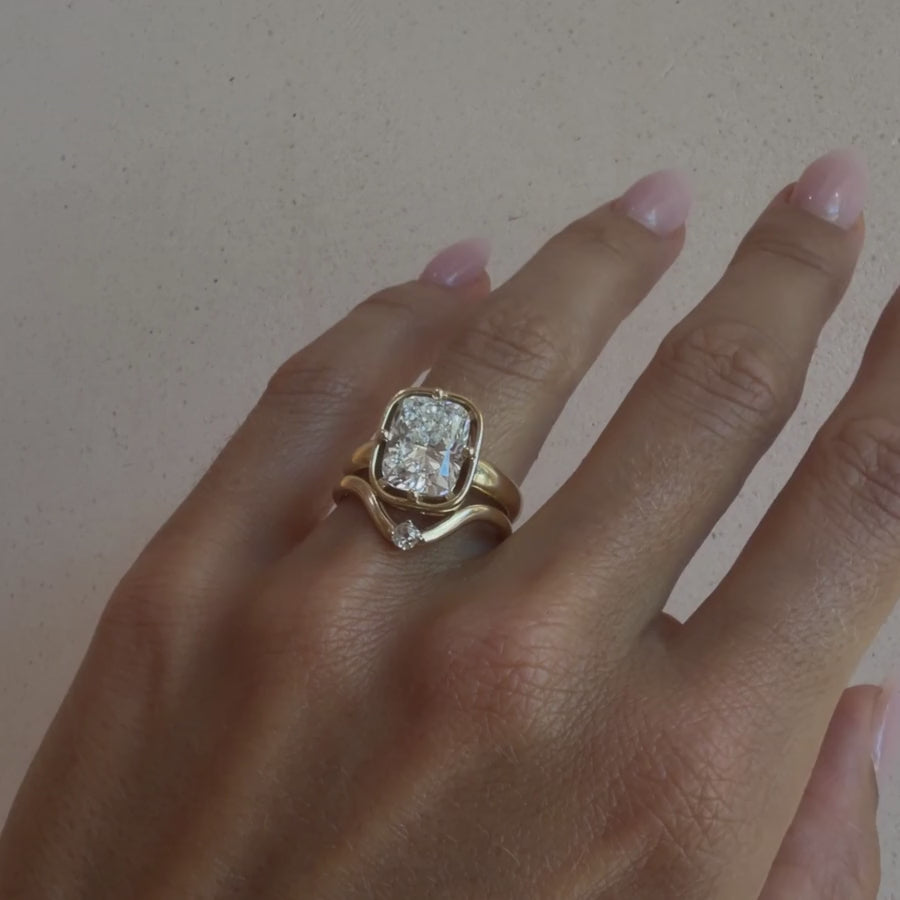 Video of the Rosette Band nested with a pear diamond engagement ring on hand