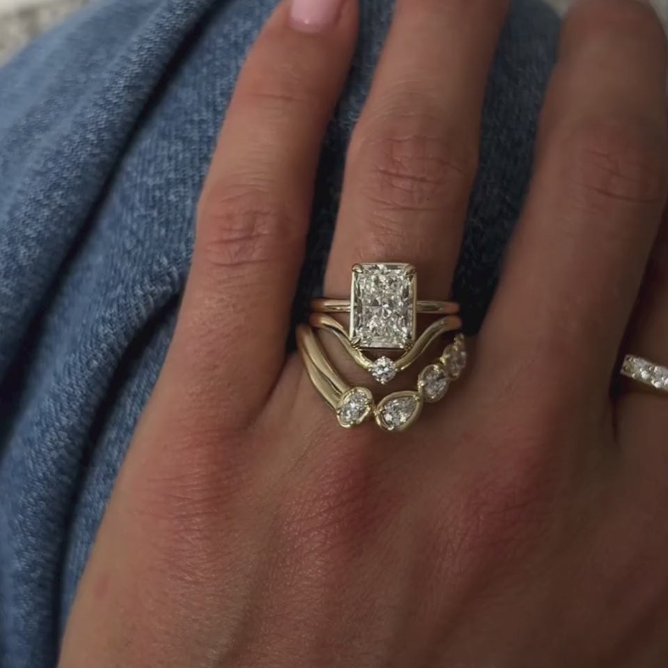 Video of the Simone Arch Band nested under a radiant cut diamond engagement ring on hand